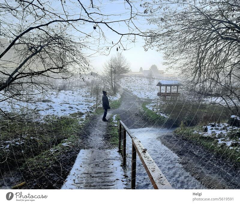 Winterspaziergang Winterstimmung Winterlandschaft Mensch Mann Senior Wasser Bach Steg Brücke Holzbrücke Schnee Dezember Weg Kälte Frost kalt frostig Wintertag