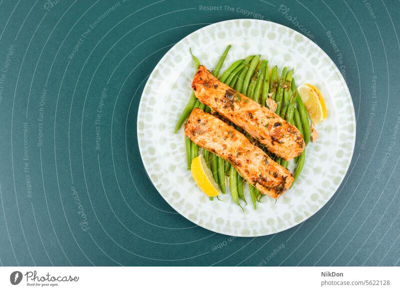 Gebackener Lachs mit grünen Bohnen oder Buschbohnen. Meeresfrüchte Fisch Steak Filet gebacken Forelle Lebensmittel gegrillt Teller grüne Bohnen Gemüse Zitrone