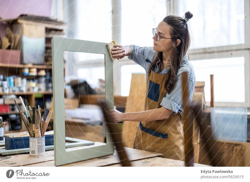 Schreinerin bei der Arbeit in ihrer Werkstatt Möbel Zimmerer wiederherstellend Schreinerei Holz Stuhl Gebäude Herstellung Handwerk Renovierung reparierend