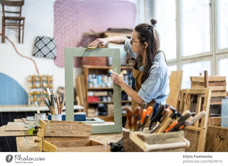 Schreinerin bei der Arbeit in ihrer Werkstatt Möbel Zimmerer wiederherstellend Schreinerei Holz Stuhl Gebäude Herstellung Handwerk Renovierung reparierend