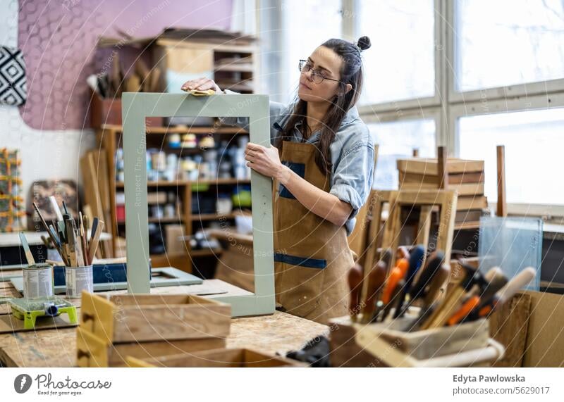 Schreinerin bei der Arbeit in ihrer Werkstatt Möbel Zimmerer wiederherstellend Schreinerei Holz Stuhl Gebäude Herstellung Handwerk Renovierung reparierend