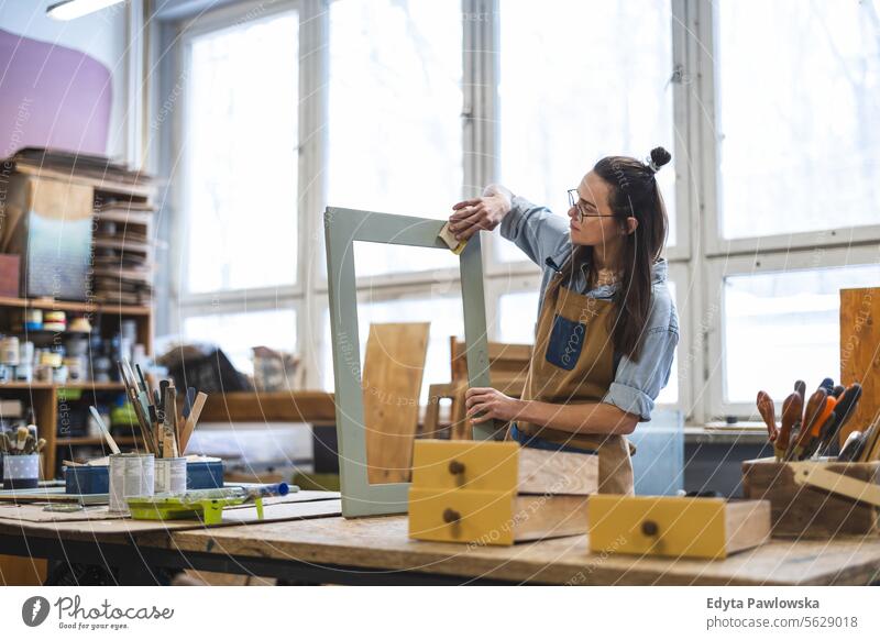 Schreinerin bei der Arbeit in ihrer Werkstatt Möbel Zimmerer wiederherstellend Schreinerei Holz Stuhl Gebäude Herstellung Handwerk Renovierung reparierend