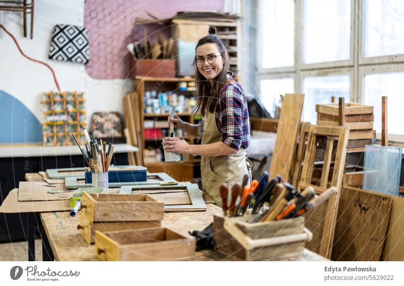 Schreinerin bei der Arbeit in ihrer Werkstatt Möbel Zimmerer wiederherstellend Schreinerei Holz Stuhl Gebäude Herstellung Handwerk Renovierung reparierend