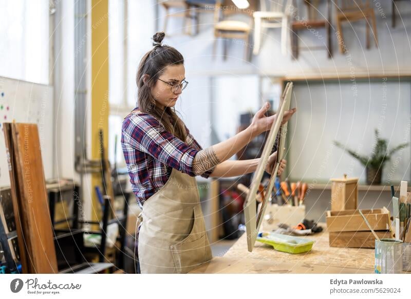 Schreinerin bei der Arbeit in ihrer Werkstatt Möbel Zimmerer wiederherstellend Schreinerei Holz Stuhl Gebäude Herstellung Handwerk Renovierung reparierend