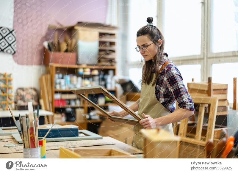 Schreinerin bei der Arbeit in ihrer Werkstatt Möbel Zimmerer wiederherstellend Schreinerei Holz Stuhl Gebäude Herstellung Handwerk Renovierung reparierend