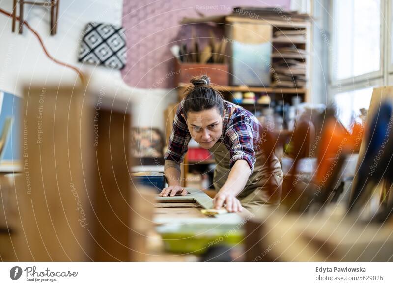 Schreinerin bei der Arbeit in ihrer Werkstatt Möbel Zimmerer wiederherstellend Schreinerei Holz Stuhl Gebäude Herstellung Handwerk Renovierung reparierend