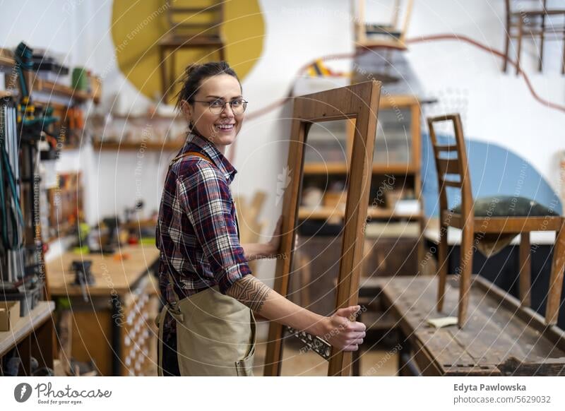 Schreinerin bei der Arbeit in ihrer Werkstatt Möbel Zimmerer wiederherstellend Schreinerei Holz Stuhl Gebäude Herstellung Handwerk Renovierung reparierend