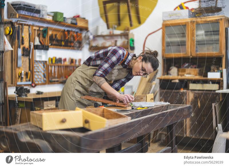 Schreinerin bei der Arbeit in ihrer Werkstatt Möbel Zimmerer wiederherstellend Schreinerei Holz Stuhl Gebäude Herstellung Handwerk Renovierung reparierend