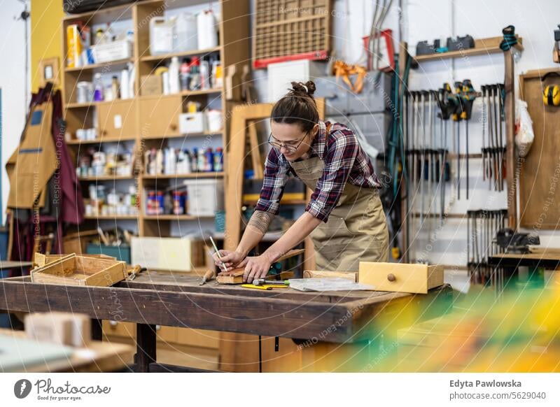 Schreinerin bei der Arbeit in ihrer Werkstatt Möbel Zimmerer wiederherstellend Schreinerei Holz Stuhl Gebäude Herstellung Handwerk Renovierung reparierend