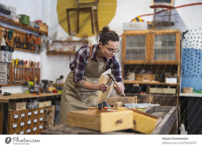 Schreinerin bei der Arbeit in ihrer Werkstatt Möbel Zimmerer wiederherstellend Schreinerei Holz Stuhl Gebäude Herstellung Handwerk Renovierung reparierend