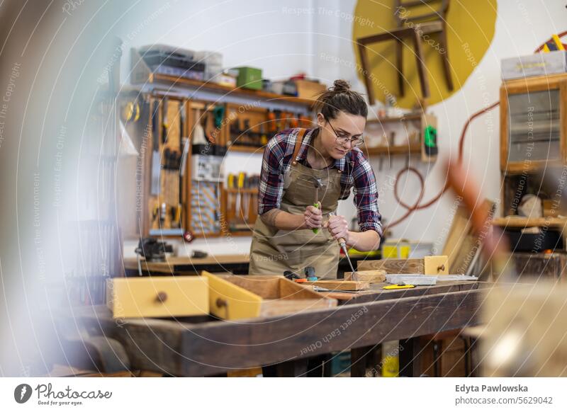 Schreinerin bei der Arbeit in ihrer Werkstatt Möbel Zimmerer wiederherstellend Schreinerei Holz Stuhl Gebäude Herstellung Handwerk Renovierung reparierend