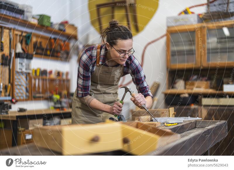 Schreinerin bei der Arbeit in ihrer Werkstatt Möbel Zimmerer wiederherstellend Schreinerei Holz Stuhl Gebäude Herstellung Handwerk Renovierung reparierend