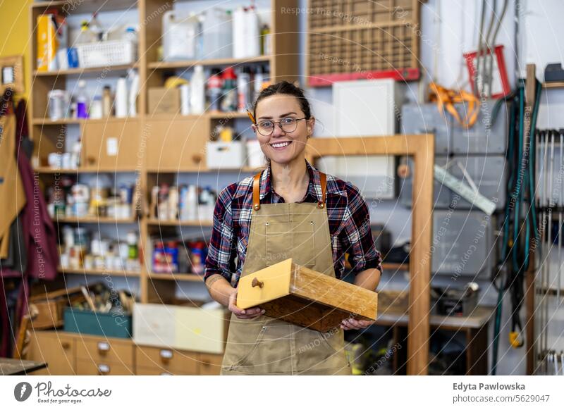 Schreinerin bei der Arbeit in ihrer Werkstatt Möbel Zimmerer wiederherstellend Schreinerei Holz Stuhl Gebäude Herstellung Handwerk Renovierung reparierend