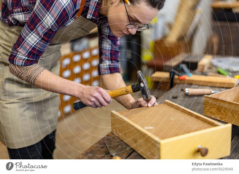 Schreinerin bei der Arbeit in ihrer Werkstatt Möbel Zimmerer wiederherstellend Schreinerei Holz Stuhl Gebäude Herstellung Handwerk Renovierung reparierend