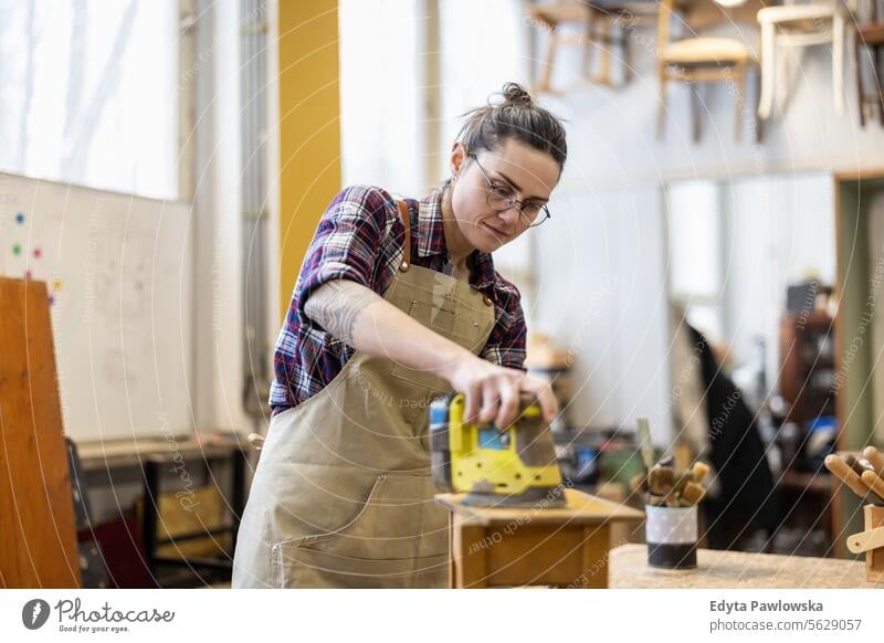 Schreinerin bei der Arbeit in ihrer Werkstatt Möbel Zimmerer wiederherstellend Schreinerei Holz Stuhl Gebäude Herstellung Handwerk Renovierung reparierend