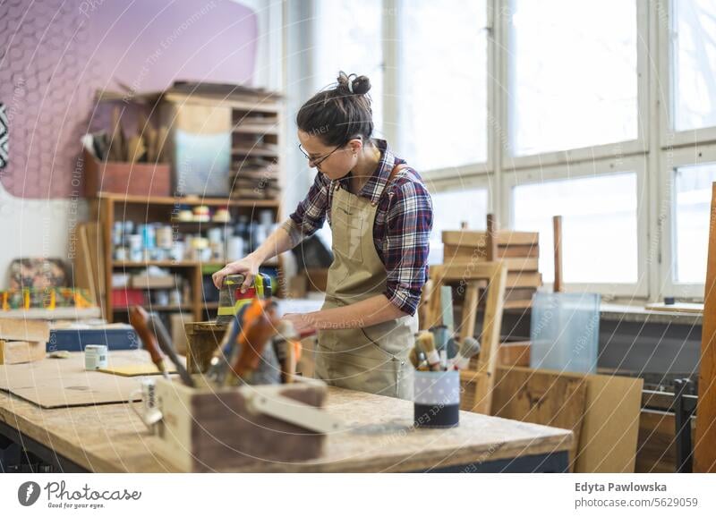 Schreinerin bei der Arbeit in ihrer Werkstatt Möbel Zimmerer wiederherstellend Schreinerei Holz Stuhl Gebäude Herstellung Handwerk Renovierung reparierend