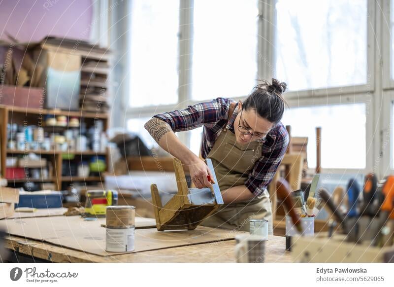 Schreinerin bei der Arbeit in ihrer Werkstatt Möbel Zimmerer wiederherstellend Schreinerei Holz Stuhl Gebäude Herstellung Handwerk Renovierung reparierend