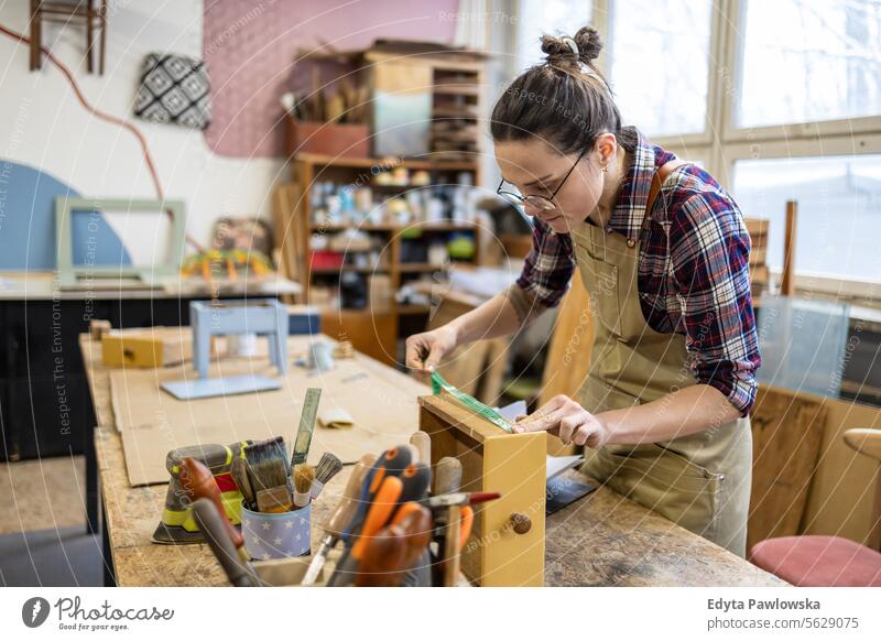 Schreinerin bei der Arbeit in ihrer Werkstatt Möbel Zimmerer wiederherstellend Schreinerei Holz Stuhl Gebäude Herstellung Handwerk Renovierung reparierend