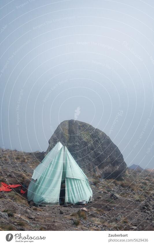 Zelt und Felsen, dahinter Wolken, auf der Lemosho-Route zum Kilimanjaro einsam Flucht Vertreibung Übernachtung Unterkunft Schutz kalt unwirtlich schlafen