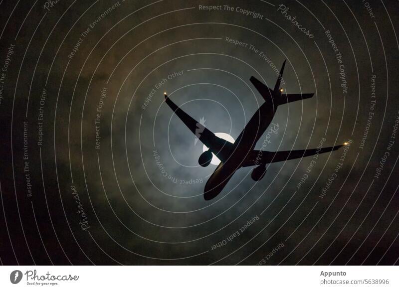 Flugzeug am Nachthimmel, im Landeanflug den leuchtenden Vollmond kreuzend Nachtflug Mond groß Silhouette Dunkelheit Passagierflugzeug Linienflugzeug