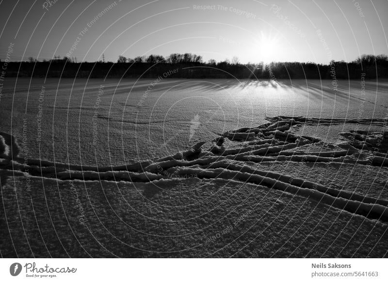 Abendlicher Sonnenuntergang über einem zugefrorenen Fluss. Aktivität Abenteuer Hintergrund kalt Entfernung Fuß Fußstapfen Fußweg Fußspur Fußspuren Frost