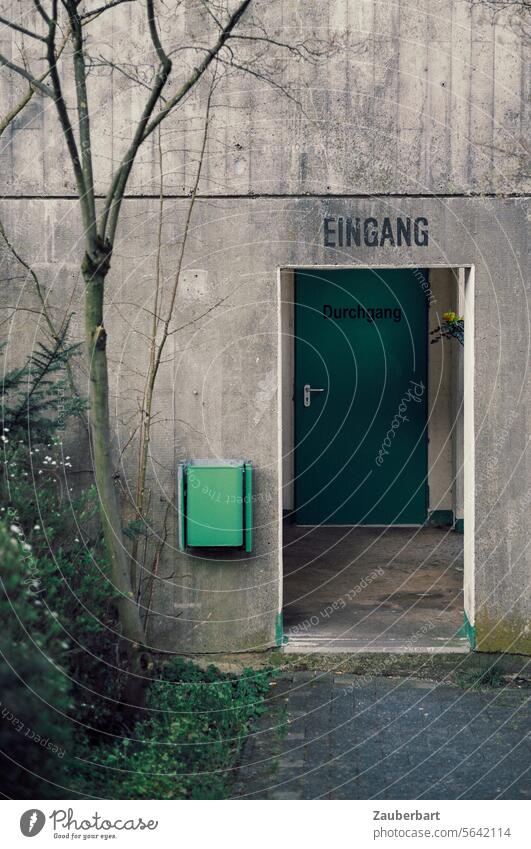 Eingang und Durchgang eines Parkhauses aus Beton, grüner Mülleimer trist trostlos funktional brut Tür Tor Ausgang Gebäude Eingangstür grau Sichtbeton modern