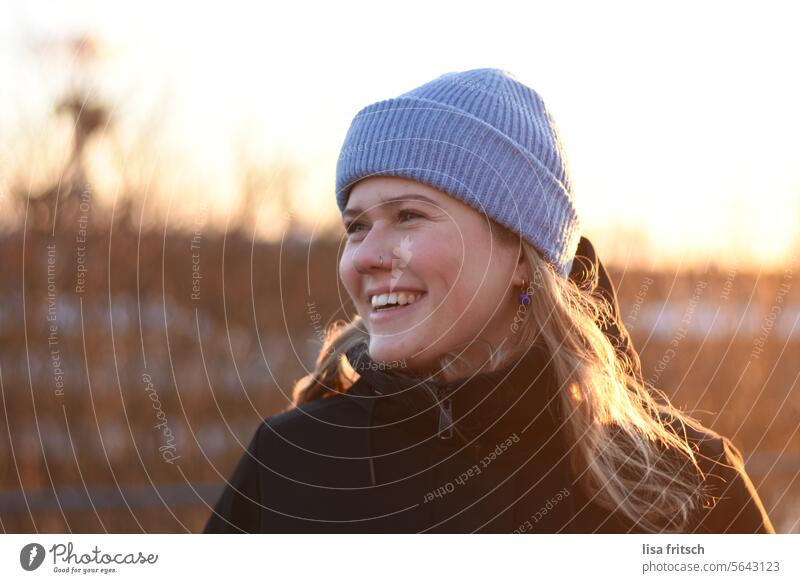 LACHEN - FRÖHLICH - SONNIGE WINTERSTIMMUNG Frau 18-30 Jahre Nasenring Seitenansicht Mütze blaue Mütze lachen Fröhlichkeit glücklich natürlich Sonnenlicht Winter