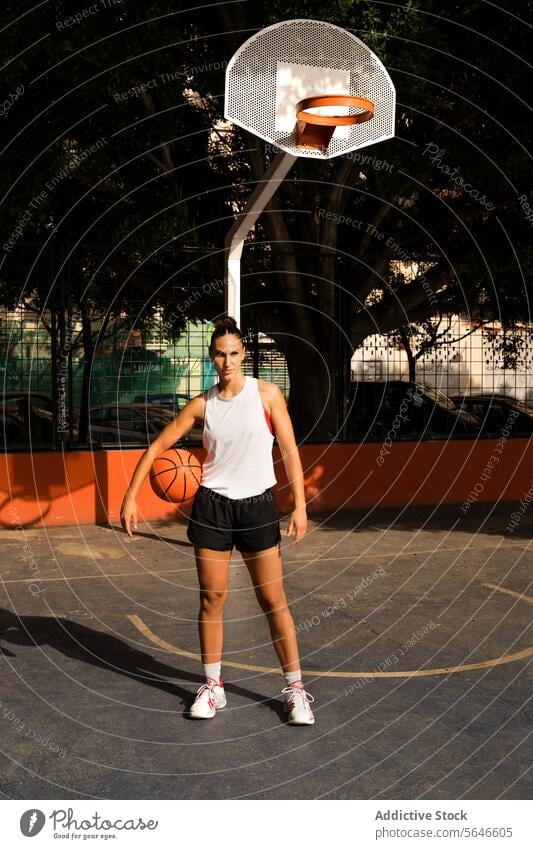 Sportlerin mit Basketball steht auf dem Platz und schaut weg Ball Spieler selbstbewusst Athlet Gericht Streetball sportlich Sportpark Frau Korb Reifen Training