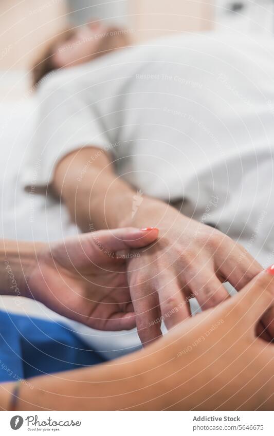 Unerkennbare Ärztin hält die Hand eines unscharfen männlichen Patienten, der auf dem Bett liegt Mann geduldig Frau Arzt Händchenhalten Uniform prüfen