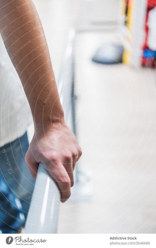 Crop-Mann hält Hand auf Metallgeländer im Krankenhaus Person modern Medizin Klinik medizinisch Stil Reling Stahl Gesundheitswesen zeigen Wiederherstellung