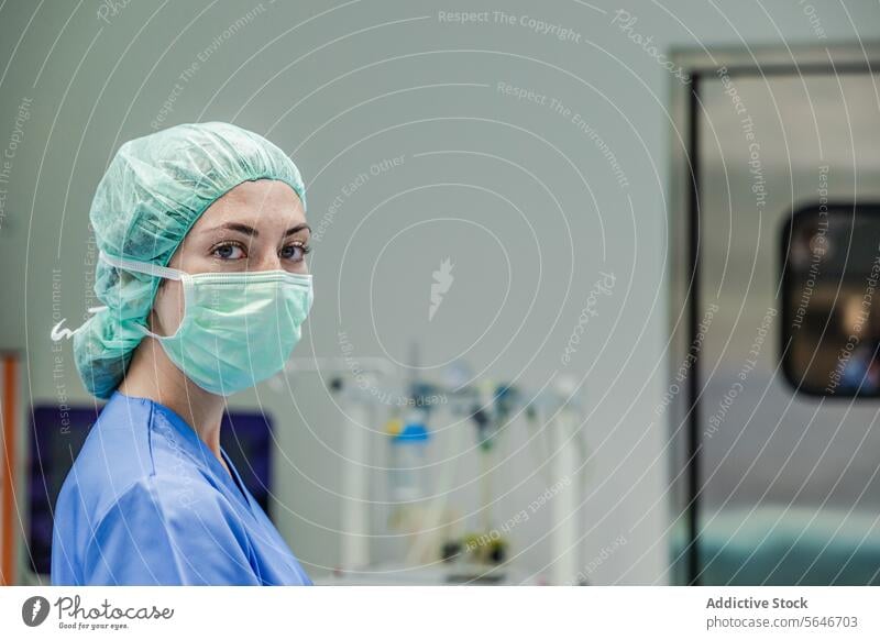 Chirurgin in Uniform mit medizinischer Maske und Kappe im Krankenhaus stehend Frau Mundschutz Arzt Klinik Arbeit Gesundheitswesen Verschlussdeckel Medizin