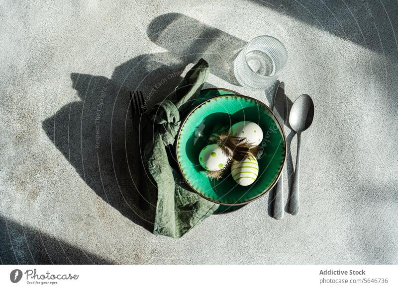 Draufsicht auf ein Dinnerset für das Abendessen an den Osterfeiertagen Ostern Tabelleneinstellung dekorative Eier Federn festlich natürlich Feier Crackle-Textur