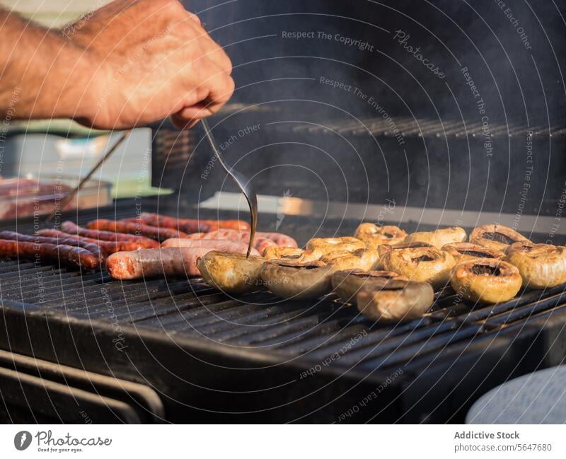 Crop Cook grillt Würstchen und Hot Dogs auf dem Grill Wurstwaren Grillrost Hotdog Koch Küchenchef Restaurant heiß Pfanne braten lecker Lebensmittel Mahlzeit