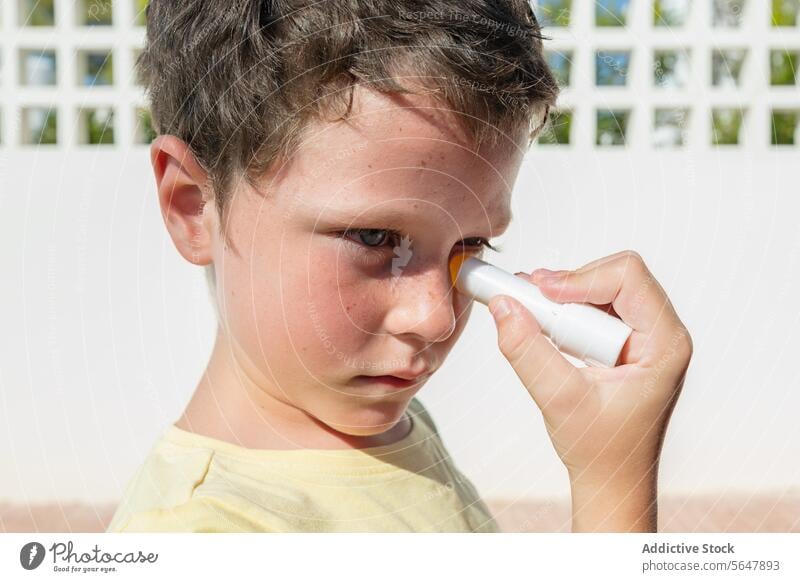 Junge trägt Sonnenschutzmittel an einem sonnigen Tag auf Kind Schutz Hautpflege Sommer im Freien Gesundheit Sicherheit Sonnenschein Gesichtspflege Sahne