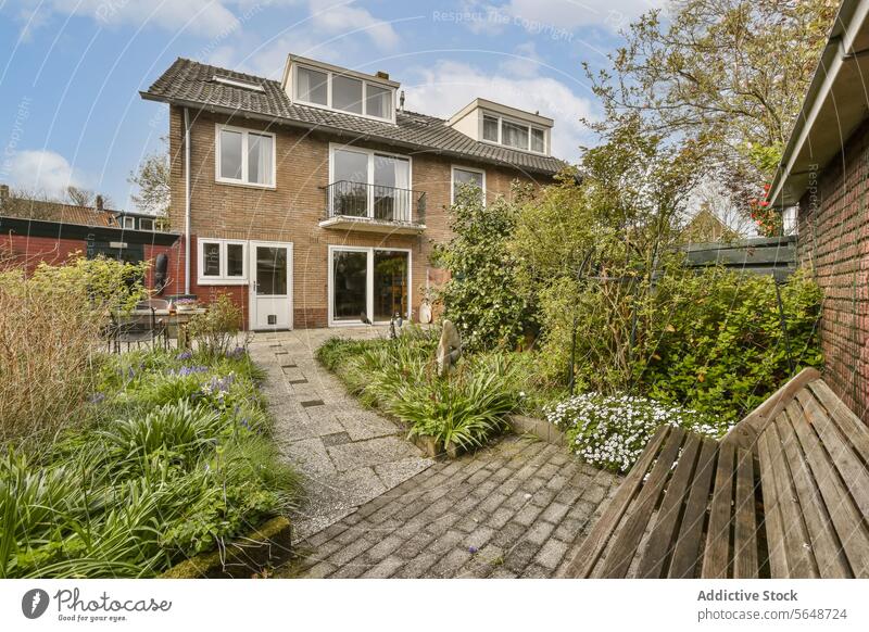 Hinterhof mit Holzbank und Backsteinhaus Bungalow Bank Pflanze Fußweg grün leer hölzern Zeitgenosse Baustein Wand Blume Haus Garten heimwärts privat Architektur