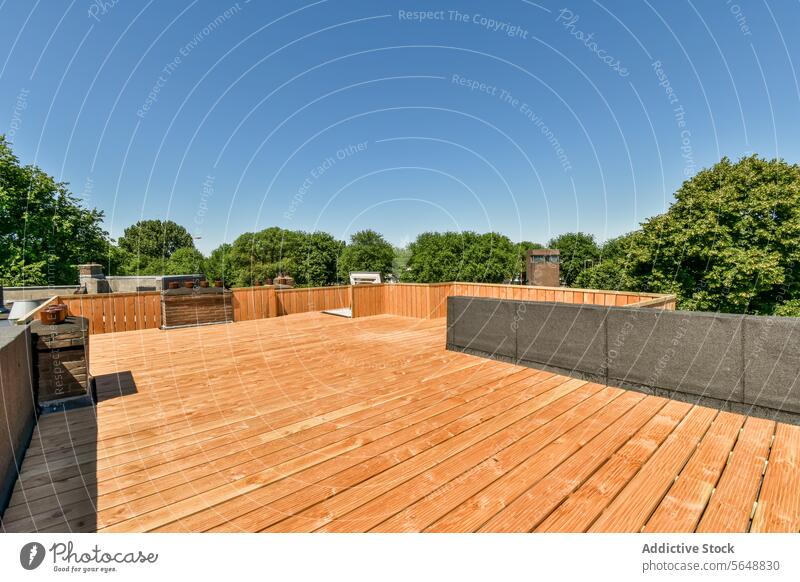 Holzterrasse mit Bäumen vor blauem Himmel Terrasse hölzern Baum Blauer Himmel leer Viertel braun sonnig Reling Dielenbrett Vorstadt Revier Sonnenlicht Anwesen