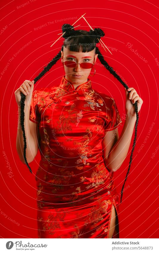 Frau in traditioneller chinesischer Kleidung mit spielerischer Pose chinesisches Kleid rot Hintergrund Mode Kultur Cheongsam Eleganz Stil asiatisch Orientalisch