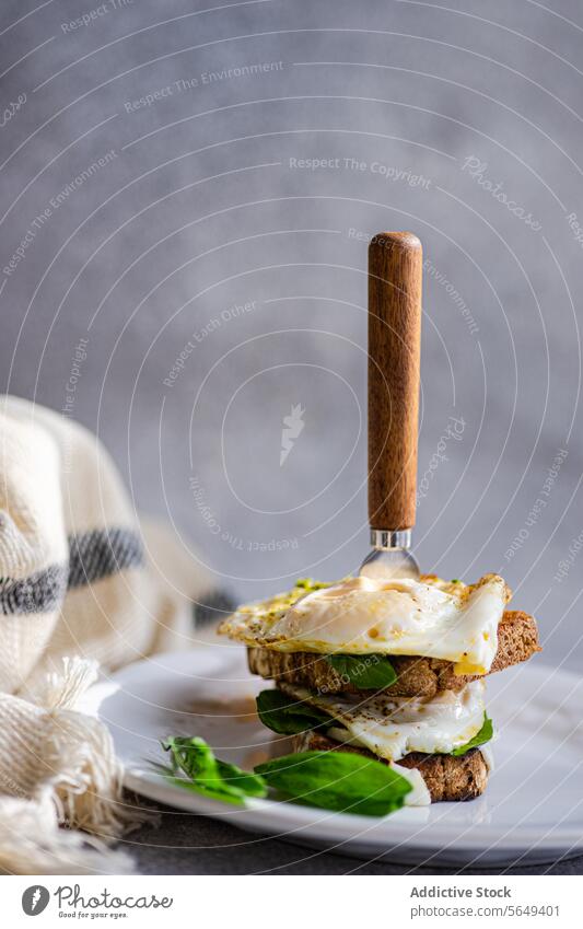 Leckeres Toastbrot mit Spiegeleiern, Blattspinat und Soße dienen Zuprosten Sahne Küche Garnierung Kraut selbstgemacht lecker frisch geschmackvoll Teller