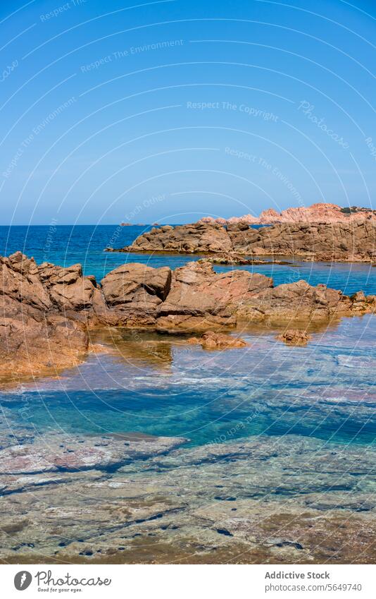 Felsiger Strand und blaues Meer unter klarem Himmel Felsen Formation Wasser Meeresufer malerisch idyllisch Gelassenheit Klarer Himmel sonnig rau braun MEER