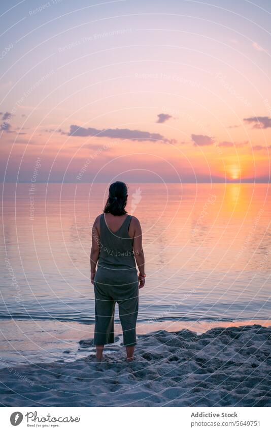 Frau betrachtet Meereslandschaft bei Sonnenuntergang Tourist Strand Sand Rückansicht unkenntlich Freizeitkleidung Lifestyle Natur Gelassenheit schön MEER Wasser