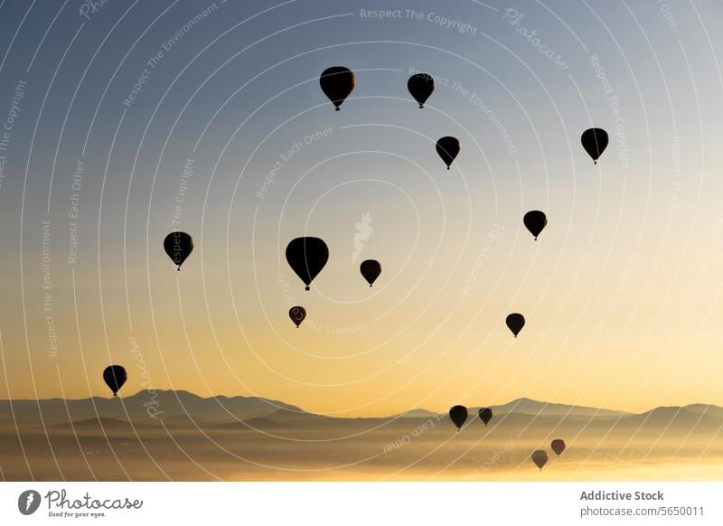 Fliegende Heißluftballons bei Sonnenuntergang an einem Touristenort Ballone Standort Ausstellung Mexiko spektakulär fliegend reisen Landschaft orange Natur