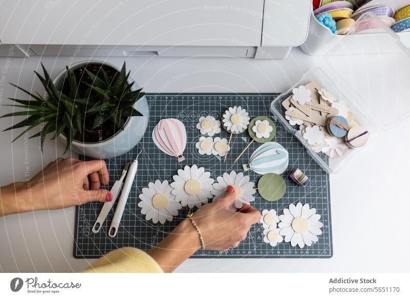 Basteln von Papierblumen und Dekorationen auf einem Schreibtisch Blumen Hände Schneidematte Werkzeuge Schere Luftballon Ordnung diy handgefertigt Hobby kreativ