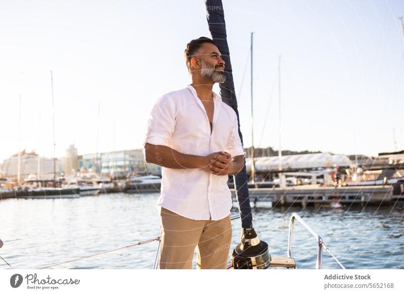 Lächelnder bärtiger Mann in weißem Hemd, der von einer Yacht vor blauem Himmel und Meer wegschaut Jacht MEER Glück Vollbart Mobile reisen sich[Akk] entspannen