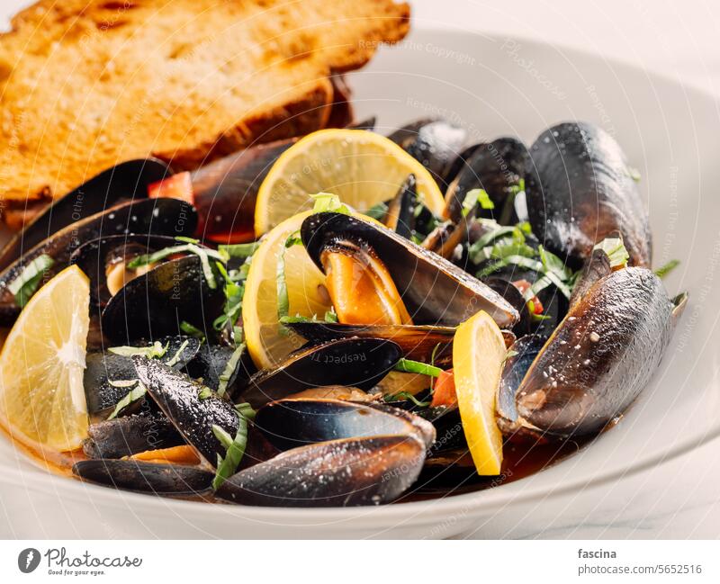 gekochte Muscheln mit Zitrone in weißer Schale Moules Meeresfrüchte Hintergrund Lebensmittel Küche Speise lecker frisch Mahlzeit Abendessen Feinschmecker