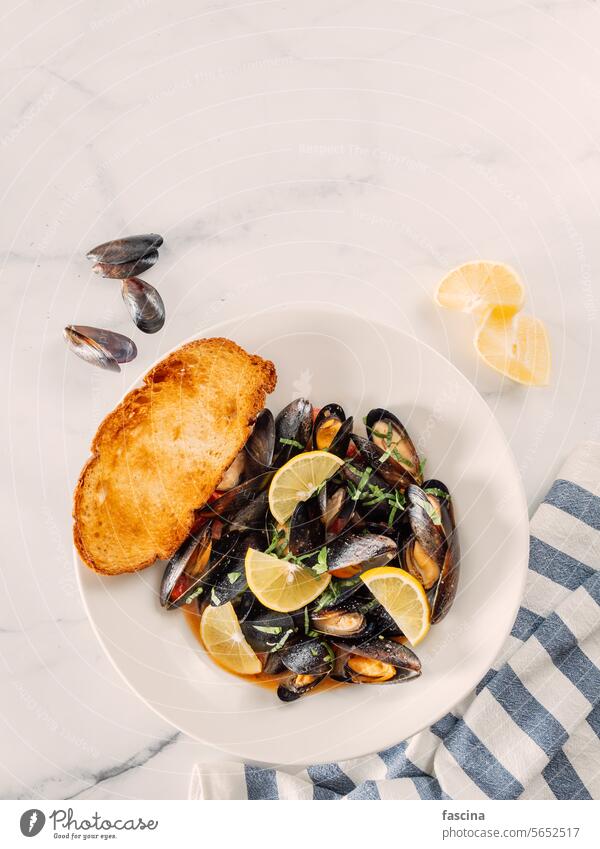 gekochte Muscheln mit Zitrone in weißer Schale Moules Meeresfrüchte Hintergrund Lebensmittel Küche Speise lecker frisch Mahlzeit Abendessen Feinschmecker