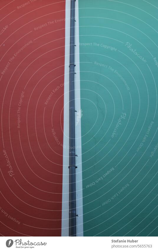 Regenfallrohr verläuft vertikal zwischen zwei farbigen Häuserfassaden Fassaden Stadt Architektur Menschenleer Außenaufnahme Mauer Farbfoto regenfallrohr