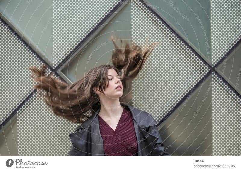 selbstbewusste junge Frau mit wehenden Haaren frau zerzaust nachdenklich sinnlich verträumt sebstbewusst elegant emanzipiert träumen urban glücklich fashion