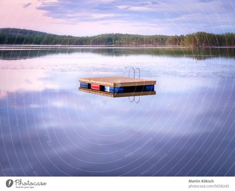 Schwimmende Insel in Schweden auf einem See bei Sonnenuntergang. Die Wolken spiegeln sich im Wasser. Schwimminsel Holzinsel Stille Schwimmvergnügen Paradies