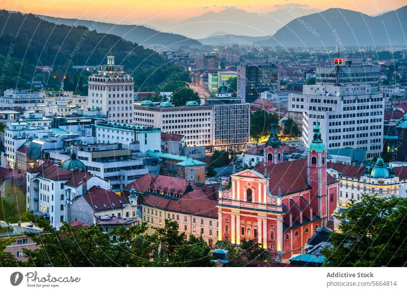 Luftaufnahme des Stadtbilds von Ljubljana bei Sonnenuntergang mit historischen Gebäuden mit roten Dächern und Bergen im Hintergrund Antenne Ansicht Slowenien