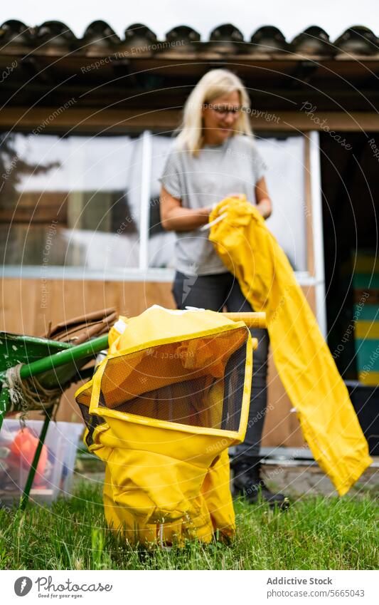 Glückliche reife Frau bei der Arbeit im Bienenstock heiter Bienenkorb Dame Imker positiv lässig Stiefel Uniform Outfit Lächeln gelb Vorschein Gebäude